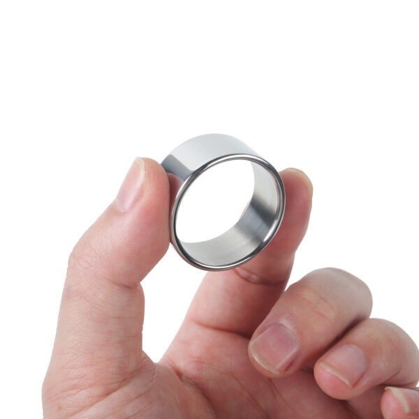 Banoch Glansring Thin brede dunne metalen eikelring omhoog gehouden tussen 2 vingers