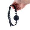 Banoch   ball gag siliconen medium   zwart Ø 4,5 cm met luchtgaten hangend in hand