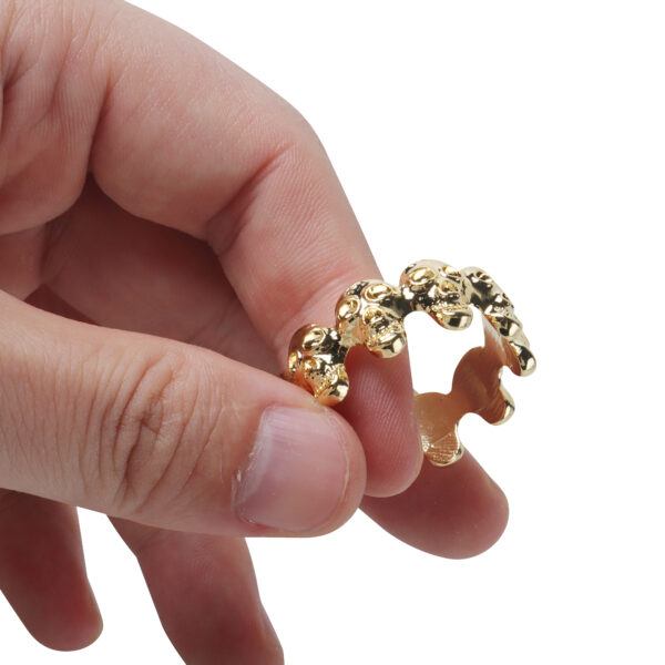 Banoch eikelring doodskop goud cockring vastgehouden in hand